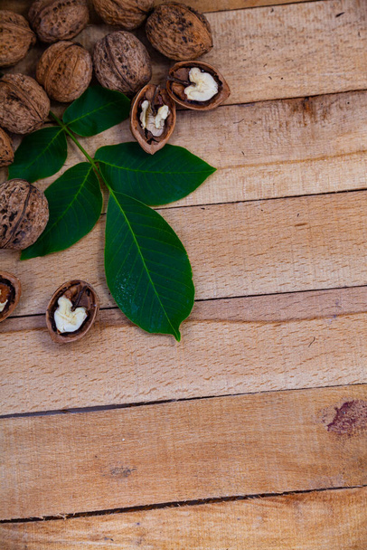 Walnuts and leaves on a wooden table.Border. Place for your text. - Fotó, kép
