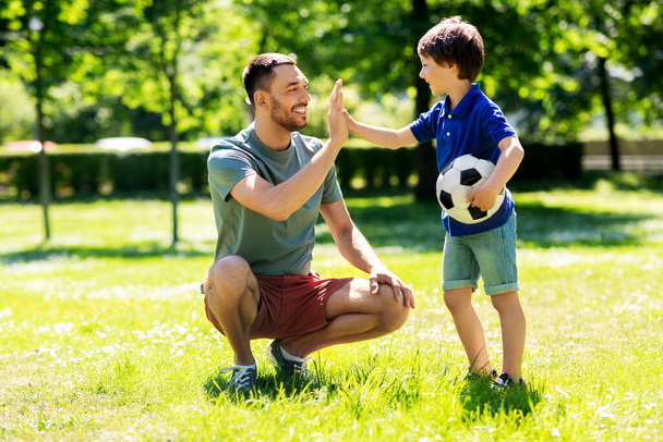 father giving five to son with soccer ball at park - Fotografie, Obrázek