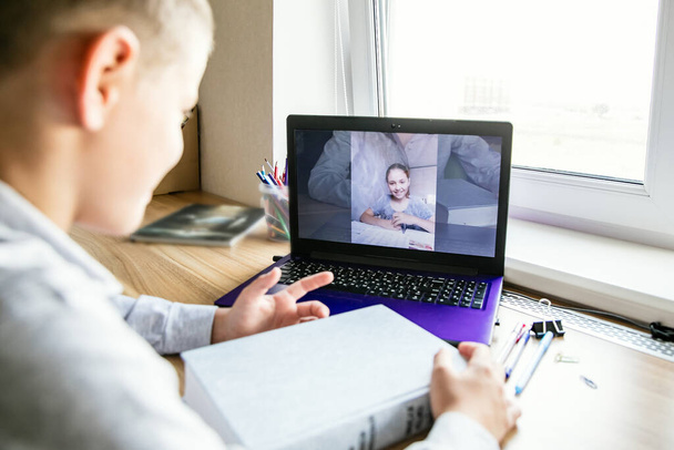A gyerekek online kommunikálnak a számítógépen. A lány és a fiú örülnek, hogy látják egymást. Baráti találkozó. - Fotó, kép