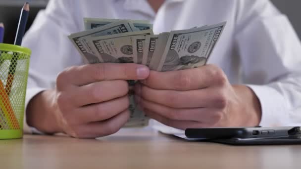 Крупним планом бізнесмен підраховує доларові купюри на столі в офісі. Долари в руці, гроші в руці, рахують гроші
 - Кадри, відео