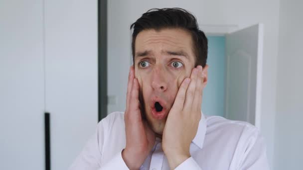 Portrait of scared businessman clutches his head showing fear and panic. Closeup shocked man on office background. Concept of fear - Footage, Video