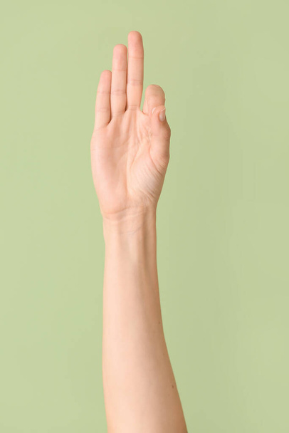 Рука показывает букву F на цветном фоне. Алфавит жестового языка - Фото, изображение