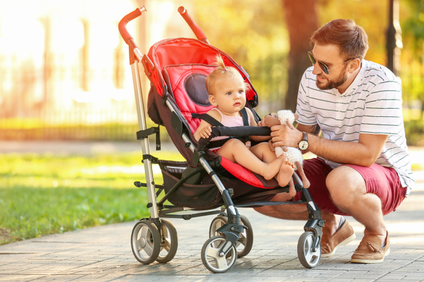 Man and his cute baby in stroller outdoors - Foto, imagen