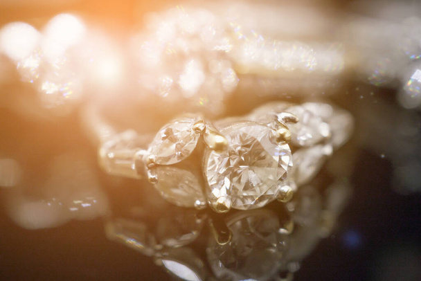 Πολυτελή χρυσά κοσμήματα διαμαντένια δαχτυλίδια με αντανάκλαση σε μαύρο φόντο - Φωτογραφία, εικόνα