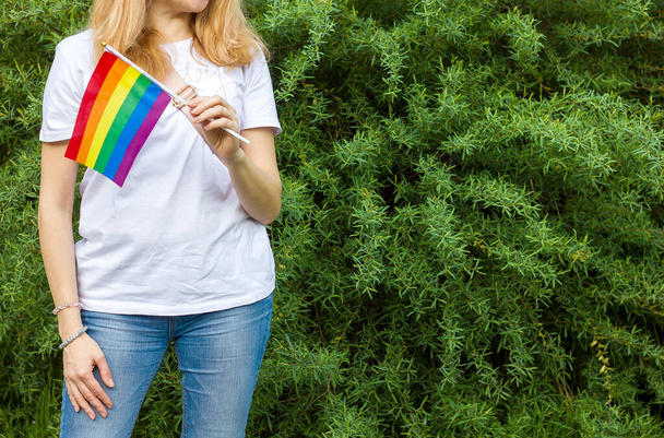 Радужный ЛГБТ-флаг в руках девушки, концепция гендерного равенства. Дискриминация лесбиянок и геев поддерживает гордость ЛГБТ - Фото, изображение