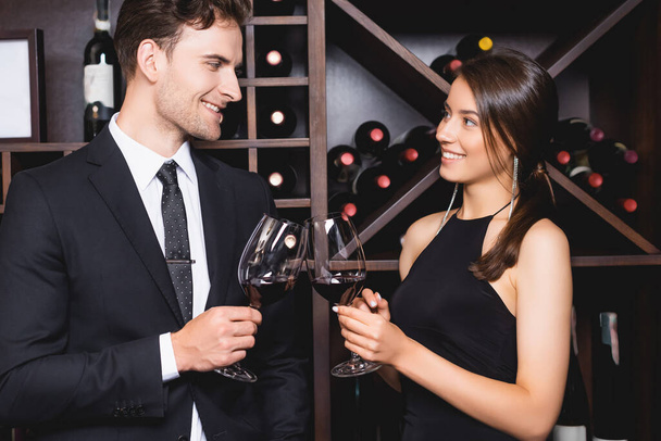 Elegant woman clinking wine with boyfriend in suit in restaurant  - Photo, Image