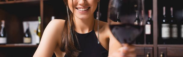 Horizontal image of woman holding holding glass of wine in restaurant  - Photo, image