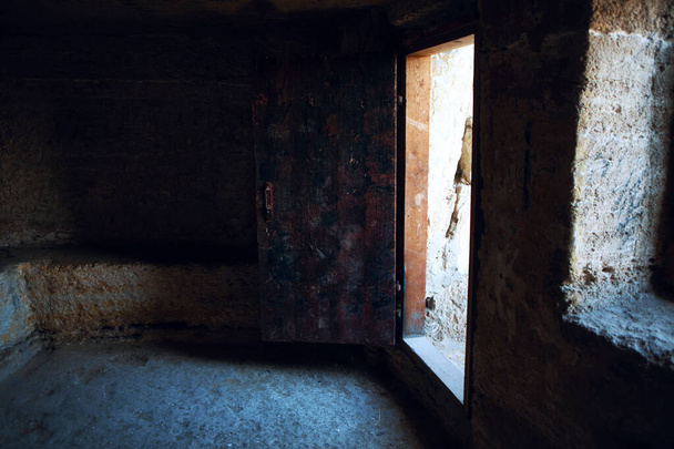 Lege stenen kamer en open oude deur  - Foto, afbeelding