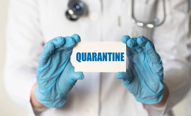 Doctor holding sign with text QUARANTINE closeup. Quarantine during coronavirus outbreak - Foto, Imagen