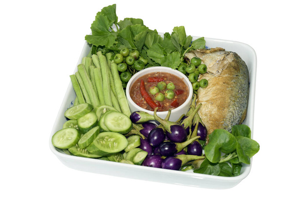 Thai cuisine "Dip with Shrimp Paste and Chili with Fried Mackerel" or " Naam Prig Gapi Pla too" in Thai. Served with many kind of fresh vegetable and Steamed Jasmine Rice isolated with clipping path. - Foto, Imagen