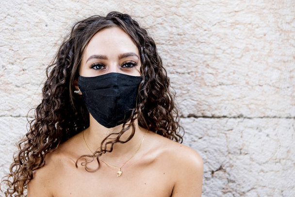 Mujer con una máscara facial contra Covid 19. Preocupación respiratoria. Máscara negra para el virus. - Foto, imagen