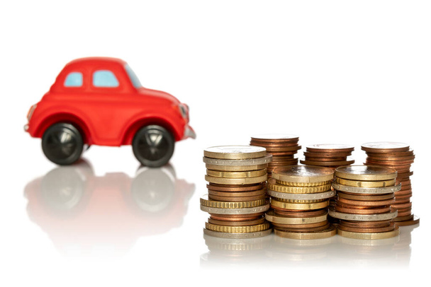 Saving for a new car. Coin stacks in front of car on white background - Photo, image