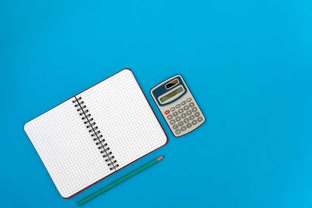  Personal organizer,calculator and  pencil on blue background - Φωτογραφία, εικόνα