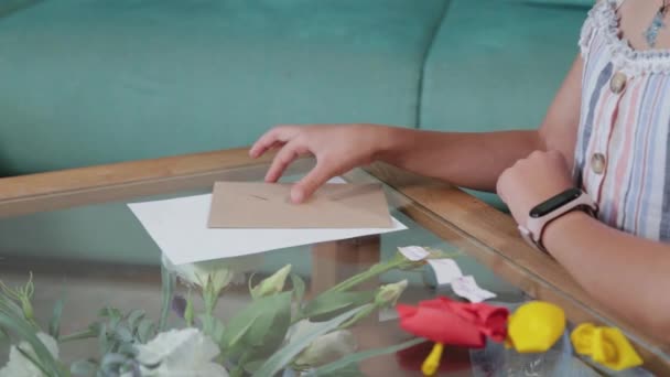 Gyönyörű lány vesz egy borítékot az asztalról. - Felvétel, videó