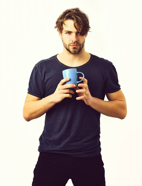 Caucasian sexy young macho holding coffee cup or mug - 写真・画像