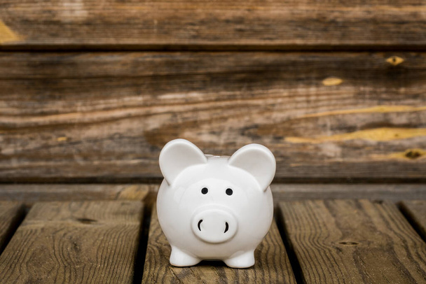 Piggy bank on the wheatered wood background. Financial savings concept. - Foto, imagen