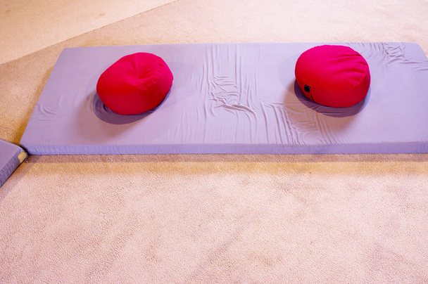 Cojines rojos de meditación sobre colchones grises - Foto, imagen