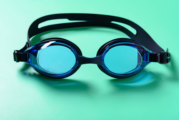 vista frontal gafas de natación azules sobre un fondo verde - Foto, Imagen