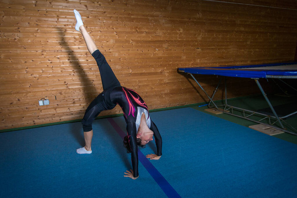 joven gimnasta en un lanzamiento en el campo de deportes - Foto, Imagen