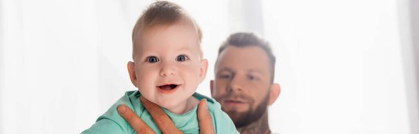 website header of young father holding infant child looking at camera with open mouth - Valokuva, kuva