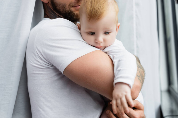 selective focus of infant boy in hands of young father - Foto, Bild