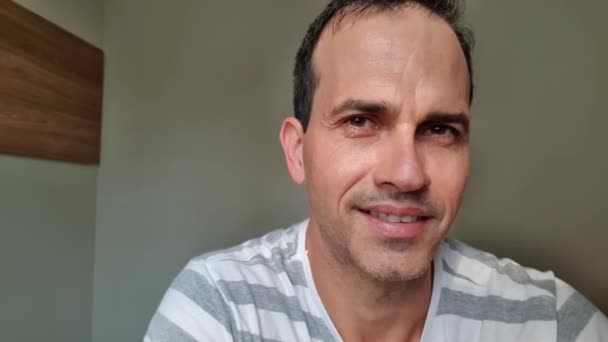Zbliżenie 44-letniego Brazylijczyka uśmiechającego się i mrugającego do kamery. - Materiał filmowy, wideo