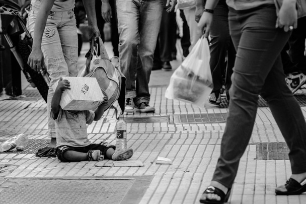 szegény kisfiú ül az utcán - Fotó, kép