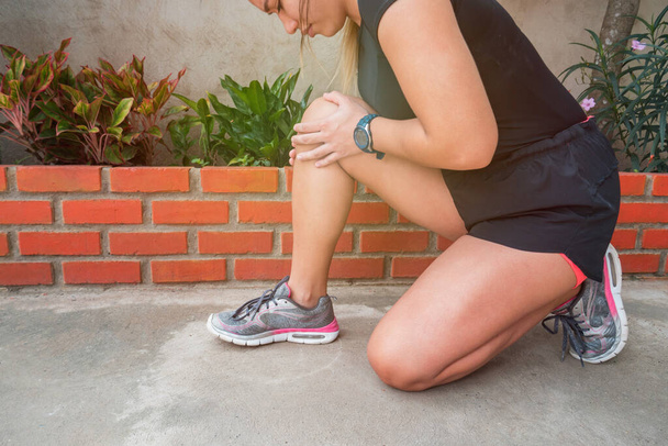 Blessure au genou - athlète coureur avec blessure sportive. Femme coureuse ayant des problèmes de genou pendant l'exercice à l'extérieur. - Photo, image
