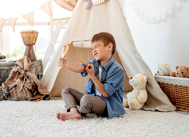 Little boy with wood slingshot - Fotografie, Obrázek