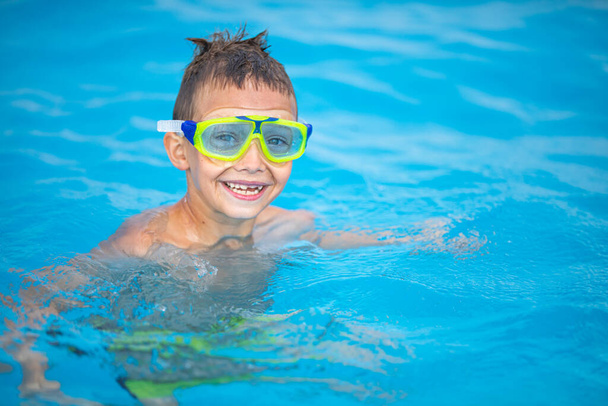 Cute little boy in a swimming pool - Fotoğraf, Görsel