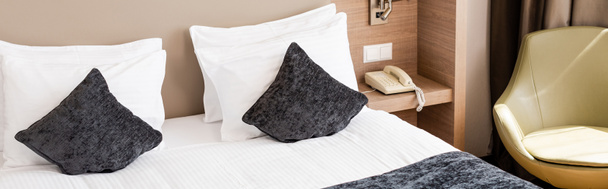 concepto panorámico de cama con manta gris y almohadas en la habitación de hotel moderna  - Foto, Imagen