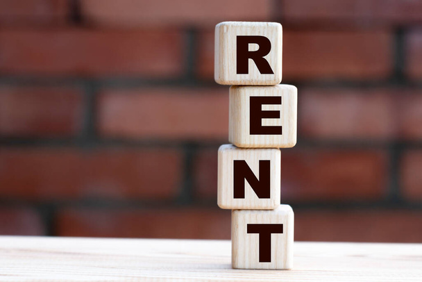 concept word RENT on cubes against the background of a brick wall. Business concept - Foto, immagini