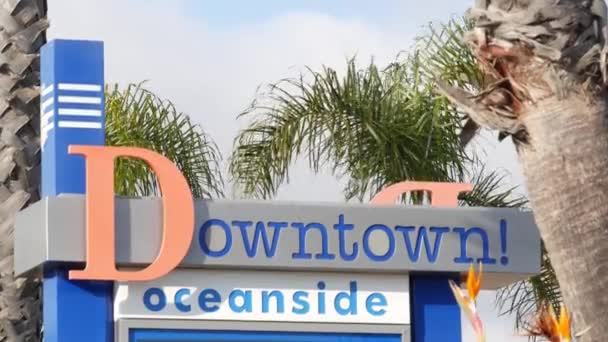 Πινακίδα Οσεανσάιντ και φοίνικες. Oside είναι το δημοφιλές αμερικανικό τουριστικό θέρετρο, Ειρηνικός Ωκεανός δυτική ακτή, San Diego County, Καλιφόρνια ΗΠΑ. Όνομα της πόλης των διακοπών και του τουρισμού στις ακτές - Πλάνα, βίντεο