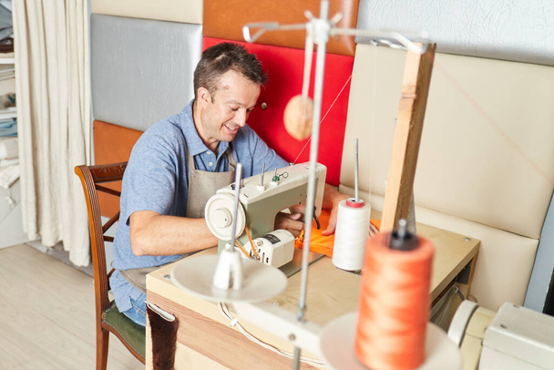 Квалифицированный рабочий, обивка мебели в мастерской по ремонту мебели - Фото, изображение