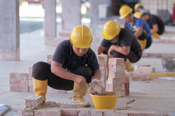 Besut, Malaysia - September 8th, 2020 : College students  working brick wall construction in bricklaying workshop - Foto, Imagen