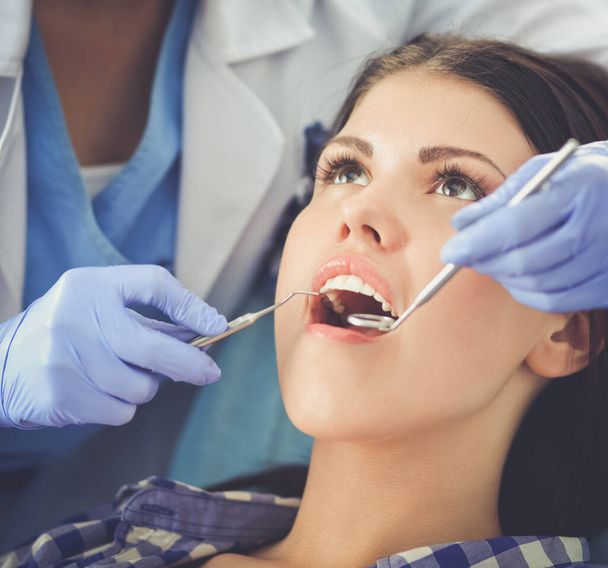 Donna dentista che lavora presso i suoi denti pazienti - Foto, immagini