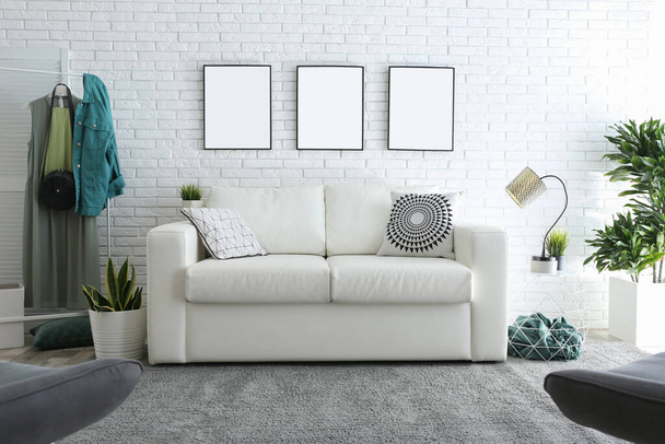Stylish room interior with empty posters on white brick wall. Mockup for design  - Fotó, kép