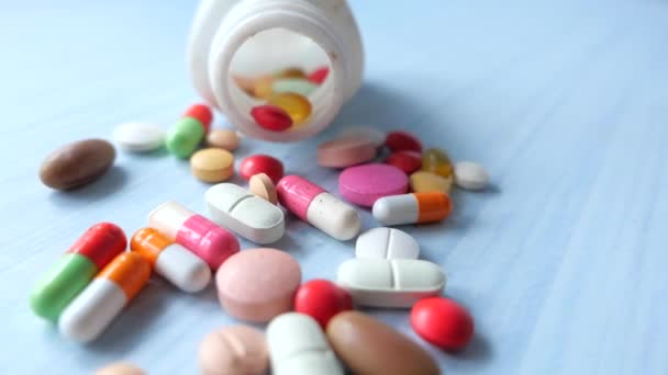 Close-up van kleurrijke pillen morsen uit een container  - Video