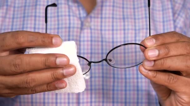 Κοντινό πλάνο του ανθρώπου χέρι καθαρισμού γυαλιών με ιστό  - Πλάνα, βίντεο