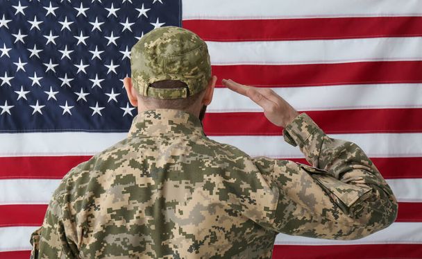 Soldier in uniform against United states of America flag, back view - Foto, imagen