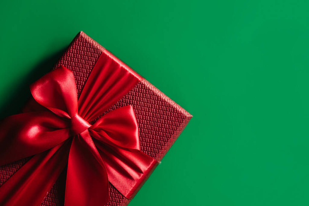 Red gift boxes on green background. Christmas card. Flat lay. Top view with space for text. - Foto, afbeelding