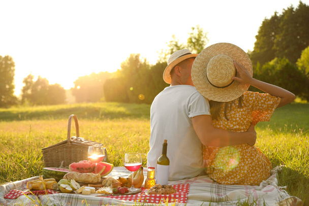 Happy couple having picnic in park on sunny day - Φωτογραφία, εικόνα