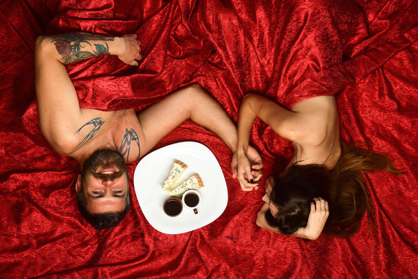 Couple in love lies on red sheets. Man with beard - Foto, Imagem