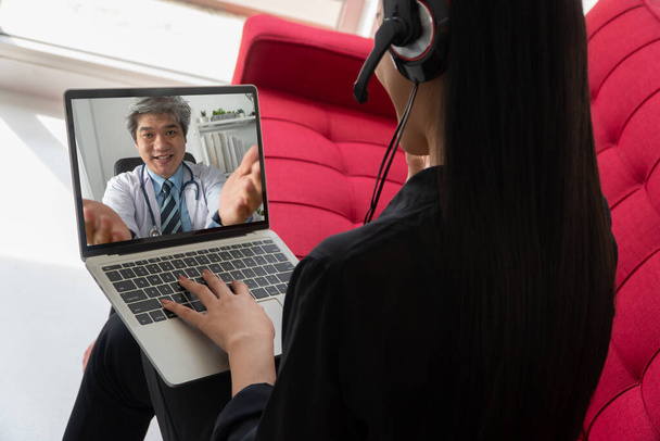 Asian doctor or therapist help relieve stress and provide knowledge and understanding about office syndrome to patients video conference call online live talk remotely at home - Photo, Image