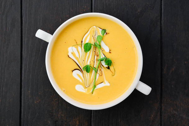 Top view of pumpkin puree soup with barbecue sauce and sour cream - Фото, изображение