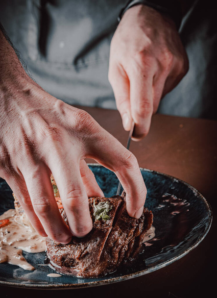 séf kézzel vágott Grillezett marhahús steak filet mignon tányéron fa asztalon - Fotó, kép