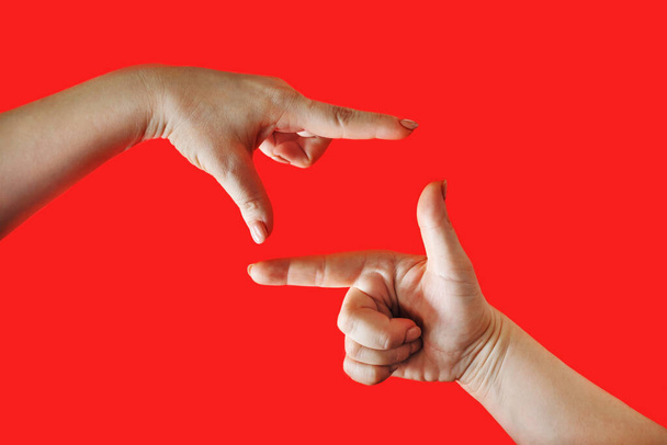 Ženské ruce dělat rám na červeném pozadí. Dámské dlaně ve tvaru rámu. - Fotografie, Obrázek