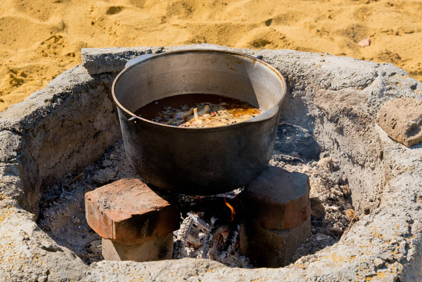Cocinar pilaf en un caldero grande sobre un fuego abierto. Primer plano. - Foto, Imagen