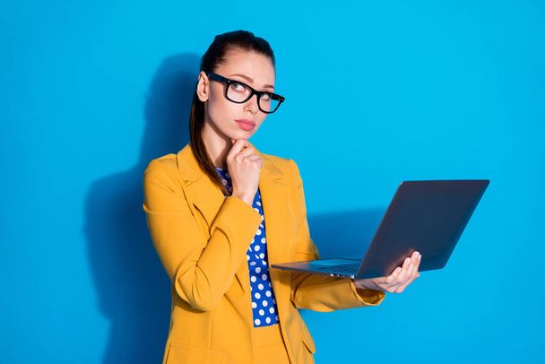 Portrait of her she nice attractive charming chic creative minded lady leader holding in hands laptop thinking planning finance isolated bright vivid shine vibrant blue color background - 写真・画像
