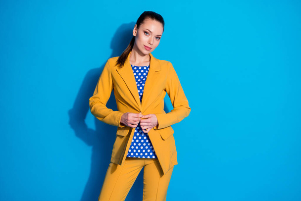 Portrait of magnificent lovely pretty chief girl adjust button blazer prepare business lawyer meeting wear yellow pants trousers isolated over blue color background - Foto, Imagen
